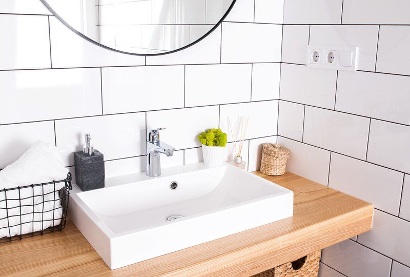 Bathroom with white tile and square porcelain sink.
