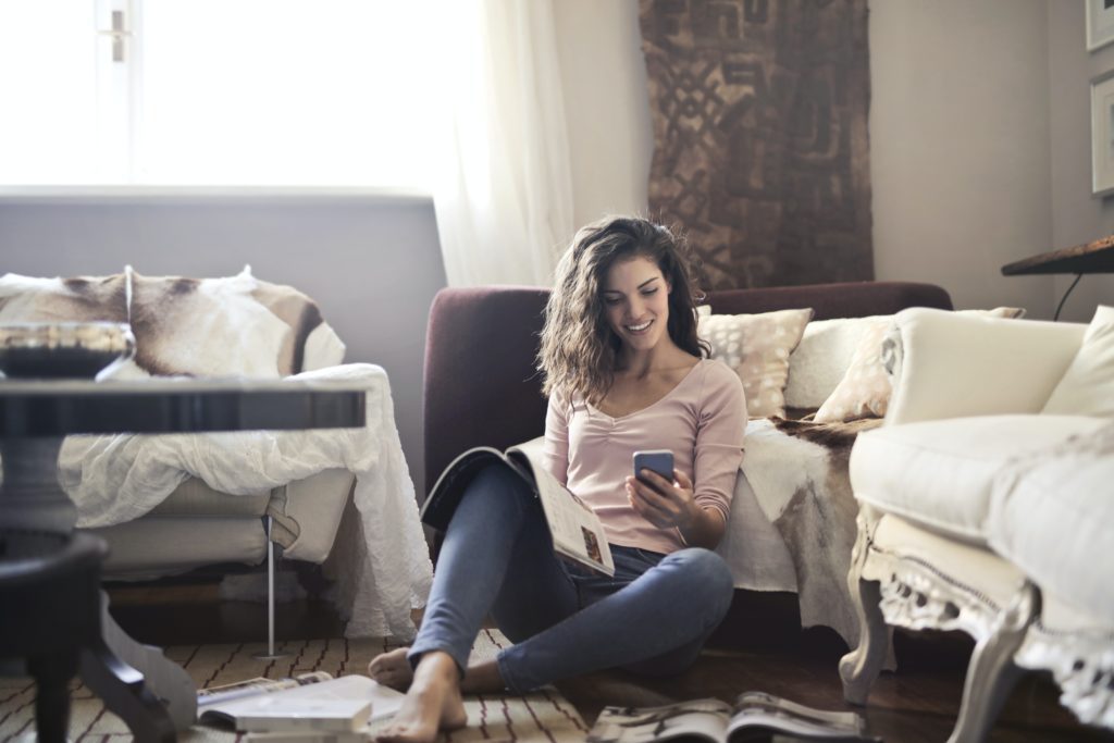 Woman looking at computer in her living room. Learning about home equity